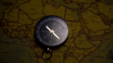 KL, MALAYSIA - Febuary 28th, 2022 : close up slow motion footage of vintage map and compass with fake lightning effects navigation and exploration concept 