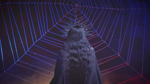 Mysterious silhouette fantasy gothic vampire woman view back. Black vintage dress cape. Girl dark queen brunette long hair. halloween costume concept. Night room, huge cobweb scenery, smoke neon light