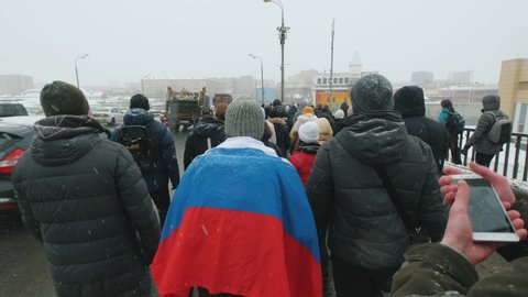Moscow - 31.01.21. Protests in defense of Alexey Navalny. Protesters walking on streets of city with Russian national banner, flag. Support of protest struggle. Fight for democratic rights together.