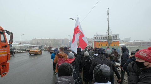 Moscow - 31.01.21, protests in defense of Alexey Navalny. Protesters walking on streets of city with Belarus national banner, flag. Support of protest struggle. Fight for democratic rights together.