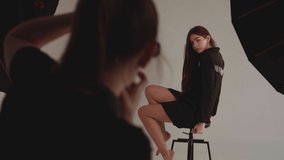 Woman photographer photographing model in studio
