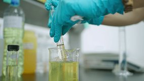 Scientist wear nitrile glove and filling up syringe with lubricating yellow oil in the lubricant laboratory. Analytical and testing the quality of oil before deliver to customer.  - Powered by Shutterstock - Get 15% off with code: PIKWIZARD15