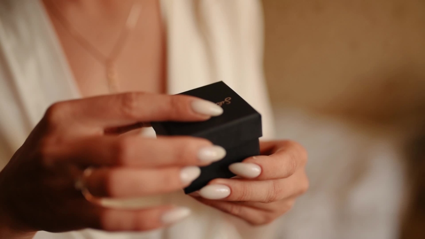 Woman hands open little black gift box with earrings. Close up view bride. Morning preparations for wedding. Accessories fashion woman jewelry. long-awaited present for Valentines day birthday Royalty-Free Stock Footage #1088178293