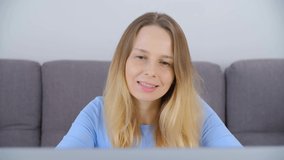 Freelance writer woman writing a book on laptop computer at home. Adult blonde female in 40s typing text on modern notebook pc with smile. Freelancer person working at home in 4k video