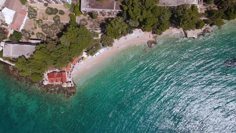 Croatia, Brac island, Bol. Aerial top down view of Dominician monastery and pebble beach on Adriatic sea. 4k drone video. Summer vacation resort