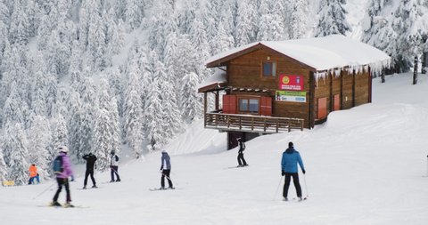 Brasov, Romania - March 9, 2022: Mountain rescue (Salvamont) hut in winter and skiers at Poiana Brasov ski resort, Postavaru massif.