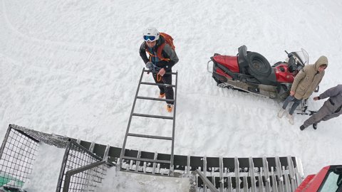 Popova Sapka, Macedonia - 11 Jan, 2022: Freestyle skiers are transported on the mountain peak by snowplow ratrack for offpiste extreme skiing, slow motion