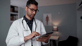 male doctor typing on a digital tablet
