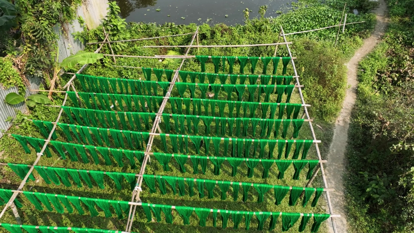 Aerial view of a person hanging to dry red cloths in Dhaka, Bangladesh.