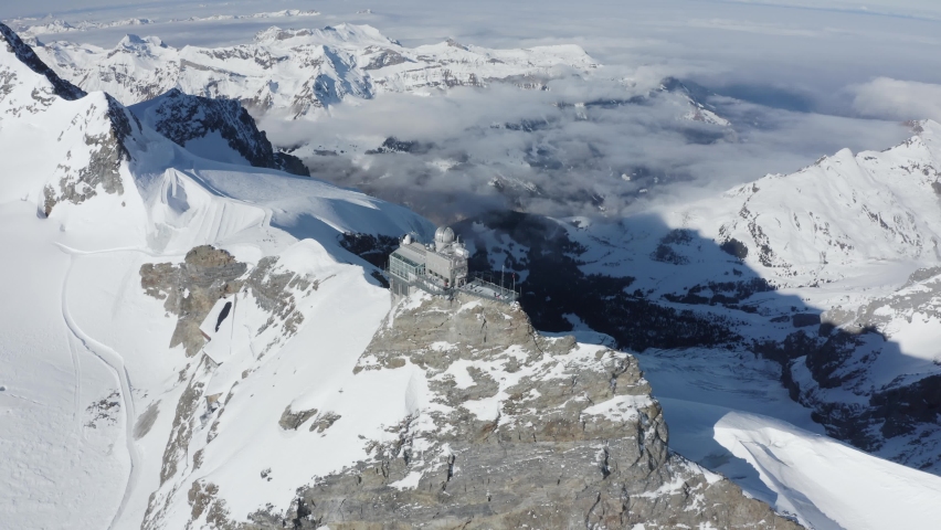 Aerial view of Jungfraujoch, a building on mountain crest with snow on Swiss Alps, Wengen, Bern, Switzerland.