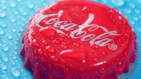 Tyumen, Russia-January 19, 2022: Coca Cola cap logo close up with water drops. Selective focus. Slow motion