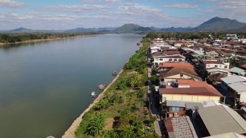 Aerial footage towards the horizon revealing this awesome view of the Laos and Thailand with the Mekong River, Walking Street in Chiang Khan, Loei in Thailand.