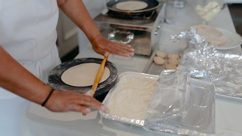 Close-up of chef's hands cooking traditional Indian bread Chapati. Roti indian bread