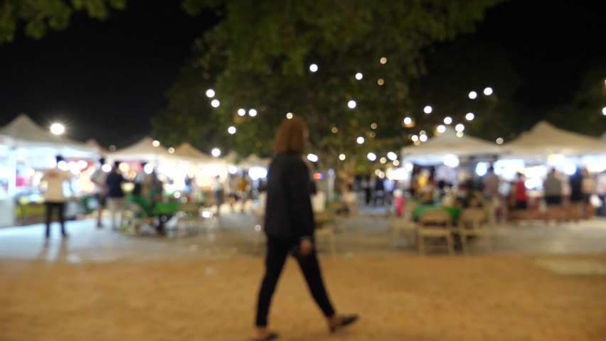Slow motion of blurred busy busy fresh market full with crowd people walking in street shopping.
Thailand street food night market booth festival light bright bokeh.