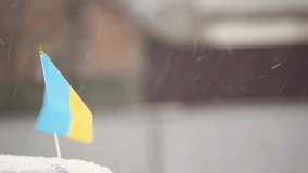Waving flag of Ukraine on car roof in snowy weather,stand with Ukraine patriotic video
