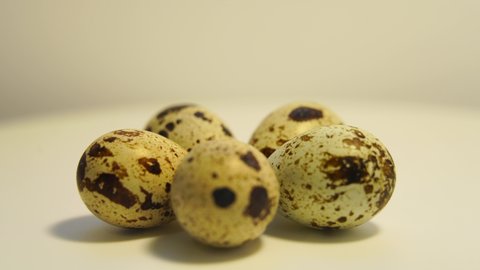 Spotted quail eggs on a light background, natural eco-friendly products.