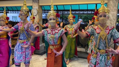 Bangkok, Thailand - March 13, 2022: Group of Thai dancers perform at Erawan Shrine, also known as Tao Maha Brahma, that houses a golden statue of Phra Phrom, the Four faced Buddha.