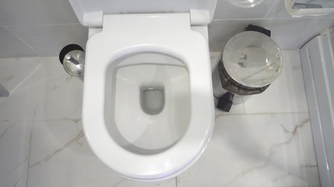 man is standing in modern toilet, and pissing in first person. stream of urine flies straight into hole of toilet. He does rim of toilet little. Modern renovation of toilet room.
