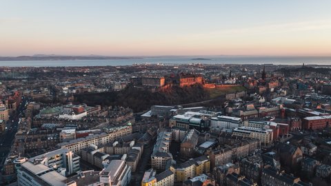 Establishing Aerial View Shot of Edinburgh UK, Scotland United Kingdom, wide, first sun wakes Edinburg Castle