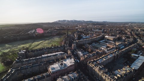 Establishing Aerial View Shot of Edinburgh UK, Scotland United Kingdom, wide view of old town and its architecture, mountains on the horizon