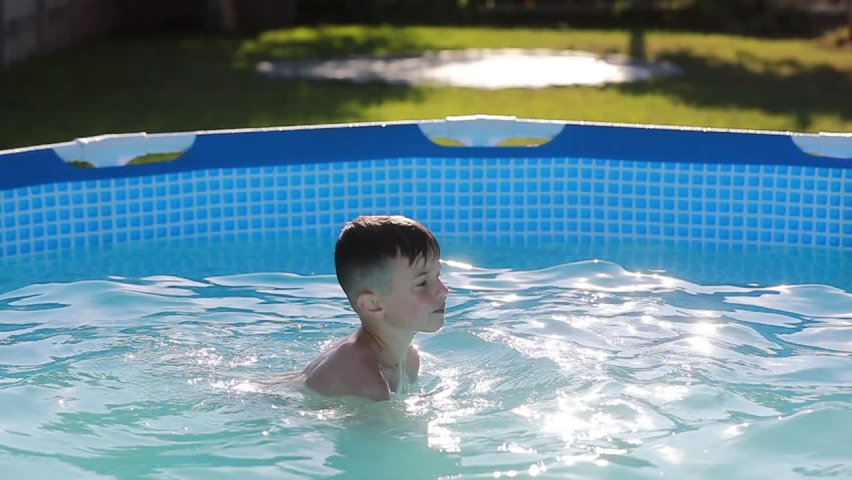smiling boy is playing in swimming pool. Summer vacation or classes. Summertime and swimming activities for happy children on the pool