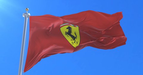 Velez Malaga, Malaga Spain - 09 24 2017: Red flag with logo of Ferrari waving at wind in slow with blue sky, loop