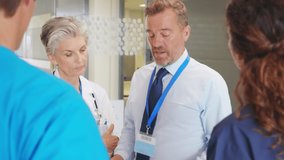 Senior woman doctor discussing patient case status with his team after operation. Pharmaceutical representative showing medical report on digital tablet about new medicine or therapy.  - Powered by Shutterstock - Get 15% off with code: PIKWIZARD15