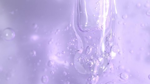 Bakuchiol serum transparent texture with dropper and slowly moving bubbles, purple liquid skincare cosmetic gel, macro shot.