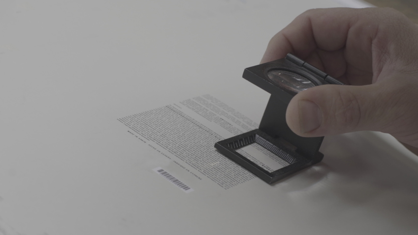 employee using magnifying glass to read text