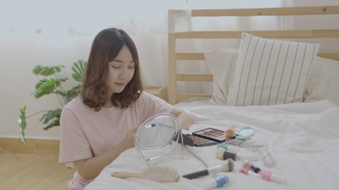 Beauty concept of 4k Resolution. Asian girls make makeup on the bed in the bedroom.
