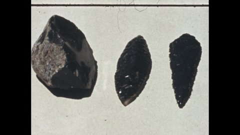 1950s: Obsidian hand axes and knives. Hand adds an arrowhead. Man adds a scoop of material to a hopper.
