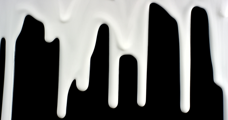Trickles of spilled white liquid flow down the black background. Isolated white paint spilled onto black paper. | Shutterstock HD Video #1088222073