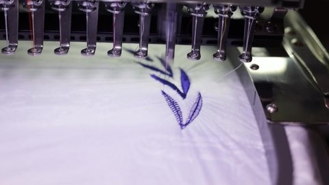 Embroidery design. Machine embroidery on a white blanket with dark blue thread. Full HD video Close up.