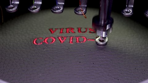 Machine embroidery of the inscription virus covid-19 on black leather with red thread. Machine embroidery design, close up 4k video.
