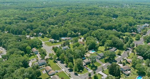 Aerial top view of a Monroe town neighborhood residential area houses in a small town on between forest landscape in NJ USA