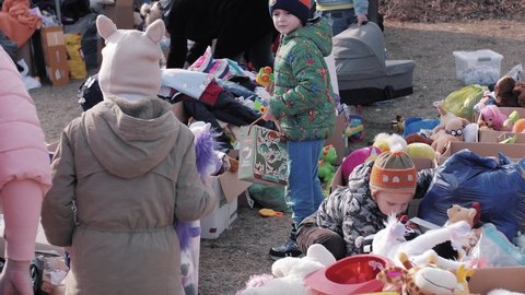 Dorohusk , Europe , Poland - 03 11 2022: Refugees from Ukraine. Children are looking for toys from humanitarian aid. Close Up. Manor house in Dorohusk at the Polish-Ukrainian border crossing in Dorohu