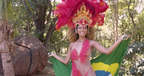 Carnival, beautiful woman, dressed for carnival party, in park, 4K, spinning, dancing and spinning, feeling of happiness, flag, flag of Brazil.