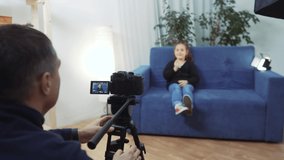 kid video blogger. videographer shoots a video blog in a studio with a little girl for an online platform. kid dream blogger records vlog backstage on camera. little youtuber girl