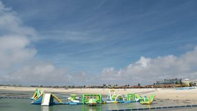OKINAWA, JAPAN - AUGUST 2021 : View of Chura Sun beach (Ocean or sea) and airplane in daytime. Clear blue sunny sky and clouds. Summer holiday, vacation and resort concept video.
