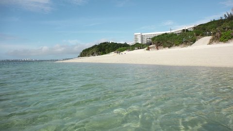 OKINAWA, JAPAN - AUG 2021 : View of Sesoko beach(Ocean or sea) at Sesoko island in daytime. Clear blue sunny sky and clouds. Summer holiday, vacation and resort concept video.