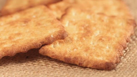 Circle crackers with salt. Close up. Rotating cracker cookies background. Tasty food. Beautiful round crackers on canvas