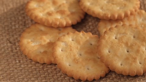 Circle crackers with salt. Close up. Rotating cracker cookies background. Tasty food. Beautiful round crackers on canvas