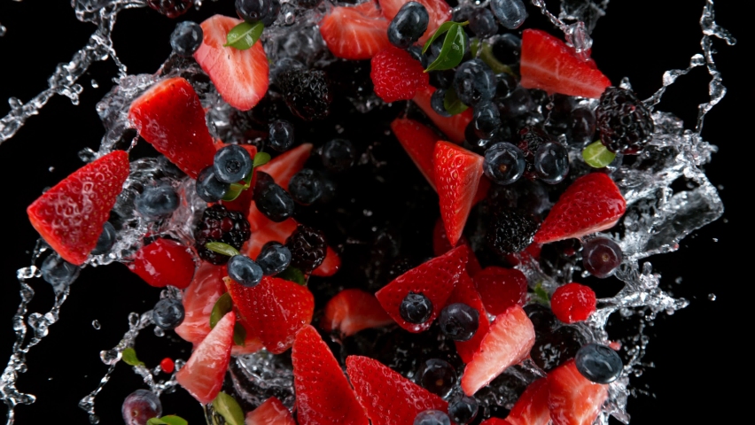 Super slow motion shot of rotating exploded berries fruit with splashing water on black at 1000fps. Royalty-Free Stock Footage #1088232451