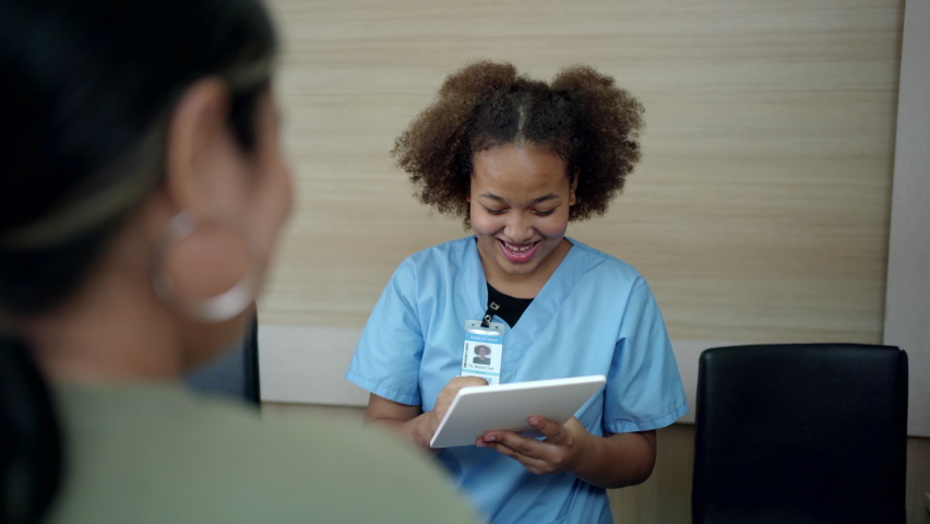 People making an appointment with medical staffs at reception desk in hospital. Medical staff and nurse - receptionist talking to patient in front of the reception counter in hospital. Royalty-Free Stock Footage #1088233117