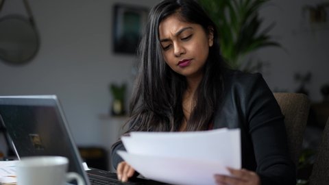 A Woman in Debt is Concerned and Stressed Looking Through Bill Letters