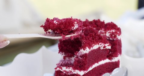 Scooping the red velvet cake with spoon. Softness of the cake texture and the smooth taste. Food concept.