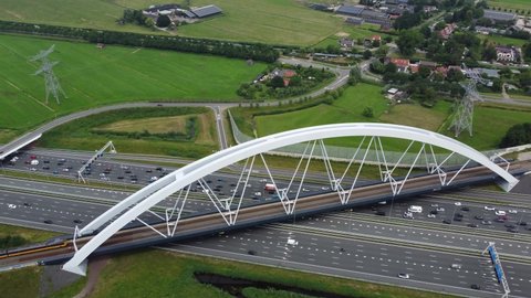 Aerial drone view of Zandhazenbrug is railway bridge with the longest span in the Netherlands located near Amsterdam and Muiderberg over the A1 motorway and part of the train line Weesp to Lelystad 4k