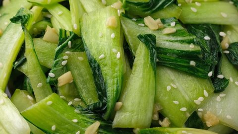 Chinese fried Pak Choi with garlic, sesame seeds and soy sauce. Healthy food. Rotating video