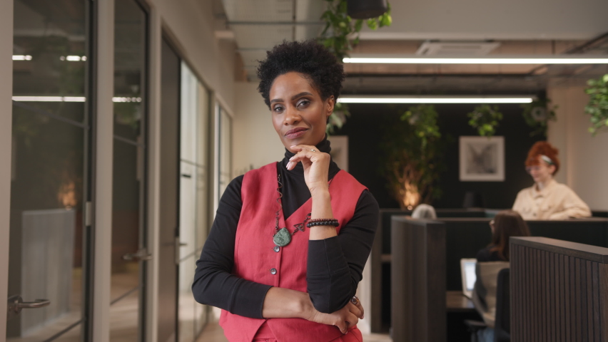 Slow motion of confident mature black woman looking at camera with hand on chin in office space | Shutterstock HD Video #1088242977