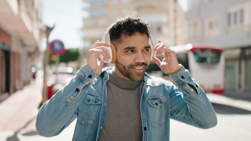 Young arab man smiling confident listening to music at street | Shutterstock HD Video #1088243427